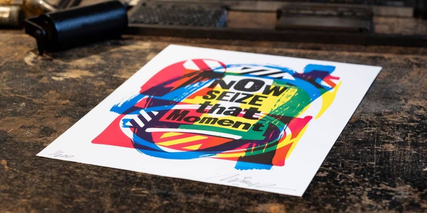The print for the Parallels project, with the text 'Now seize that moment', lying on the bed of a Wharfdale press