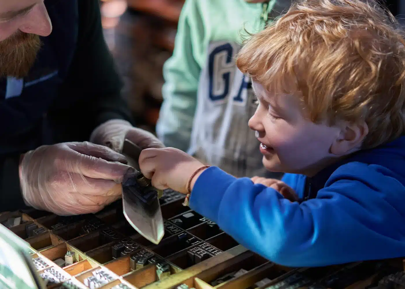 Boy looking closely at type blocks