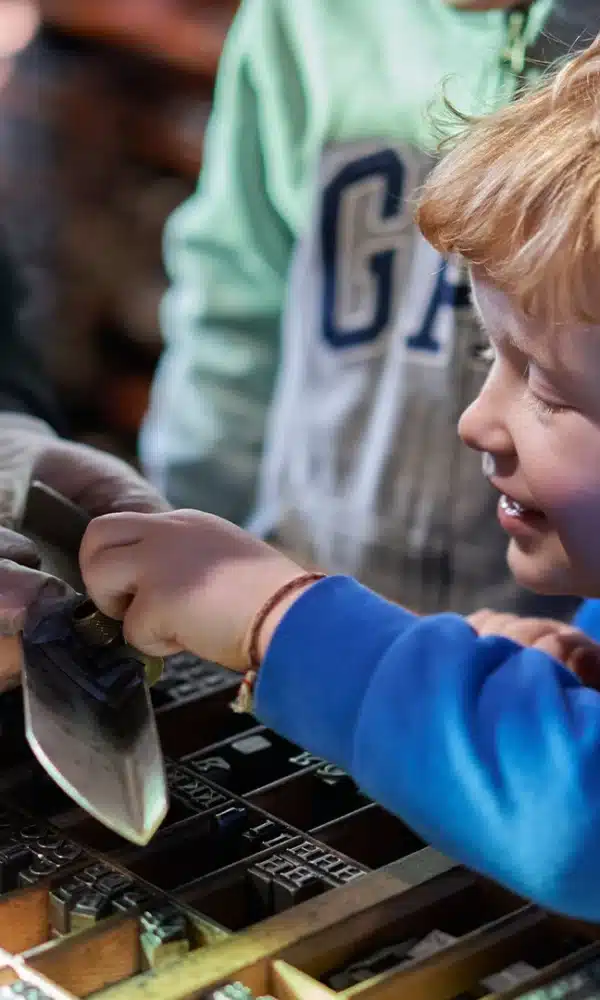 Boy looking closely at type blocks