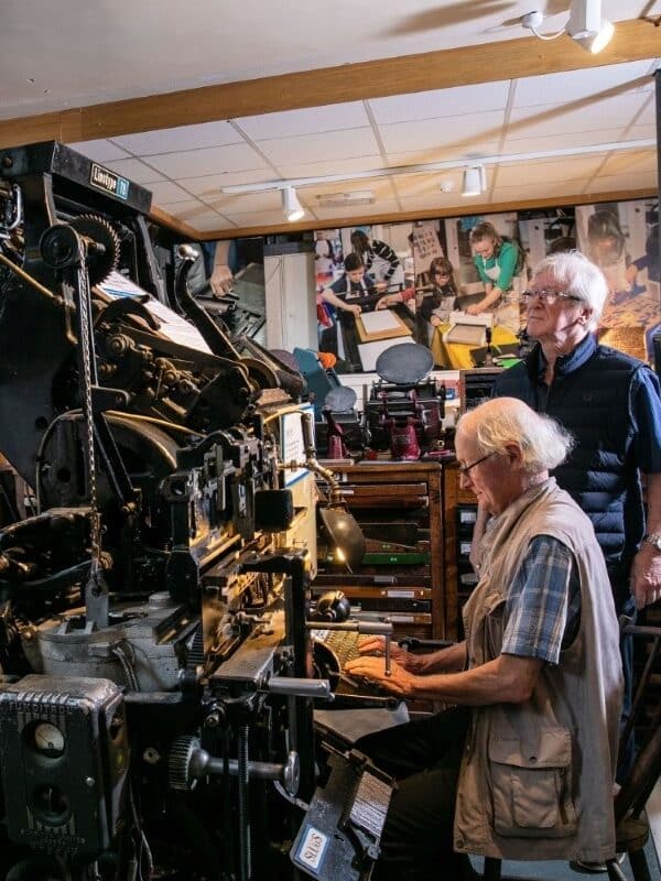 Retired compositors demonstrating the linotype machine