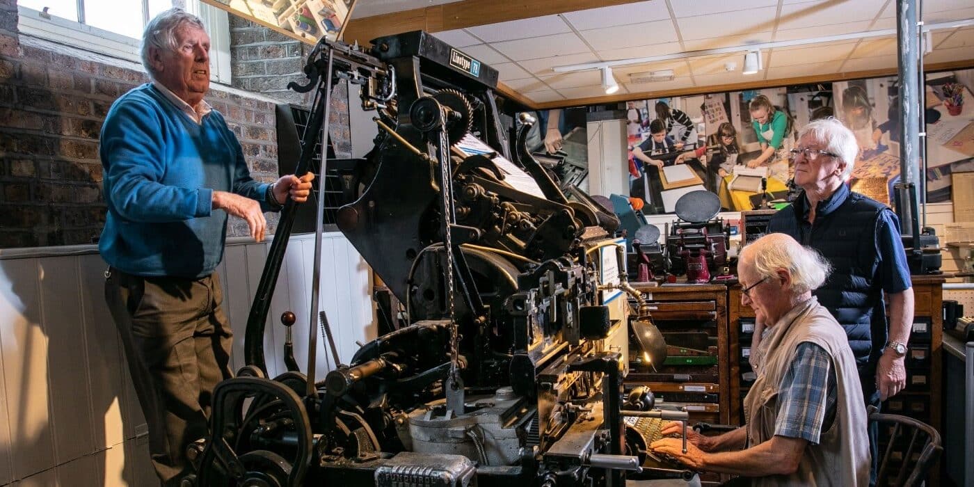 Retired compositors demonstrating the linotype machine