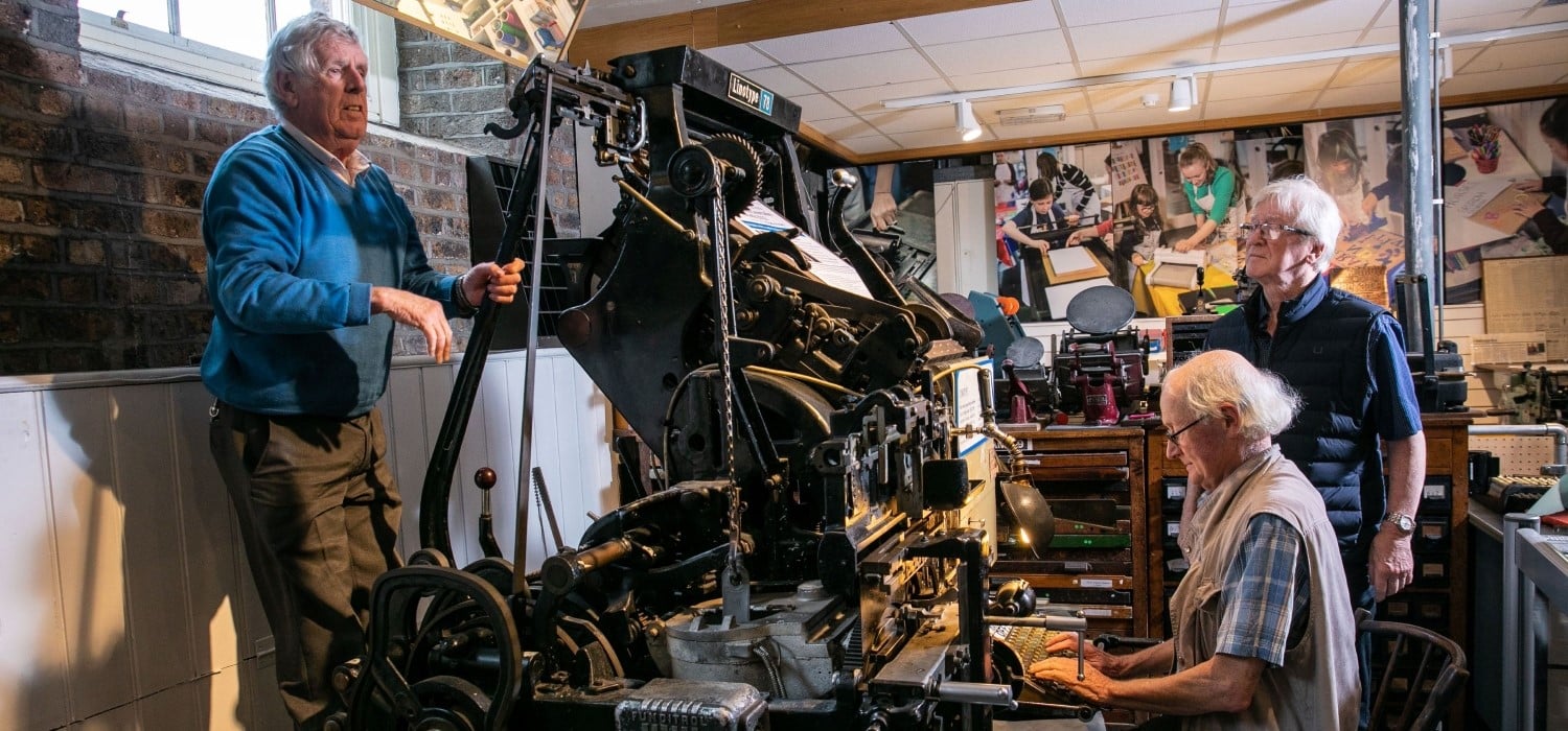Retired compositors demonstrating the linotype machine