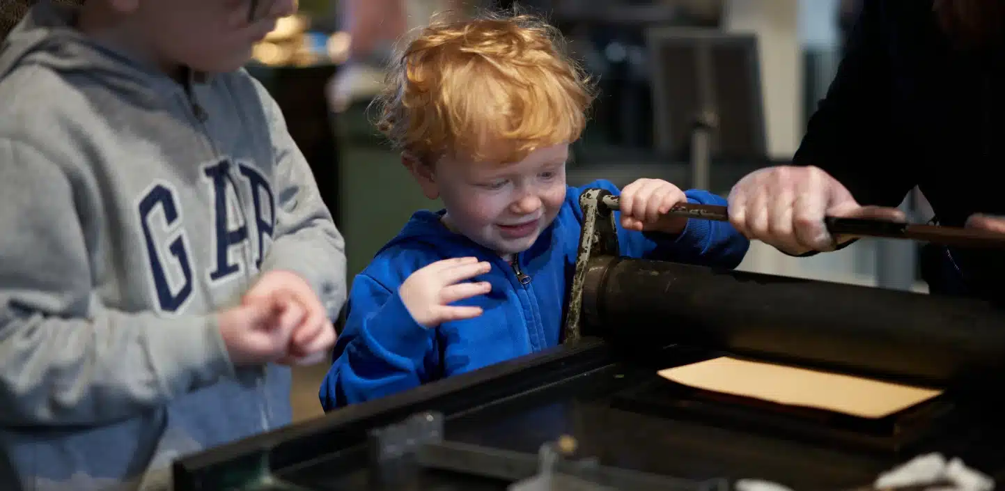 children observing printing machine