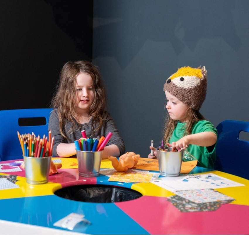 Two children making crafts in creative corner