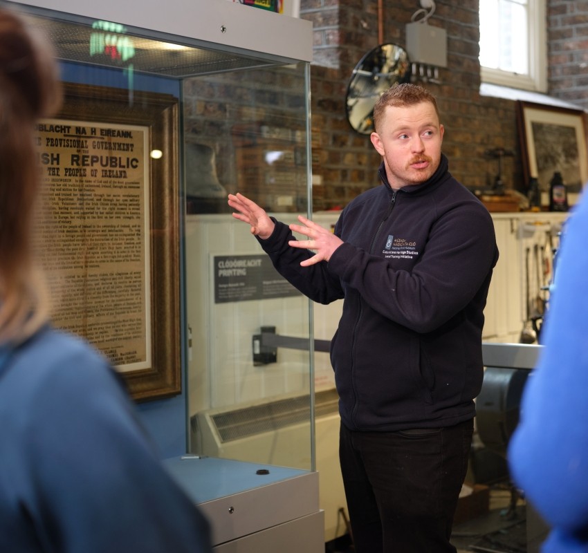 A tour guide gestures to a copy of the Irish Proclamation on display behind him