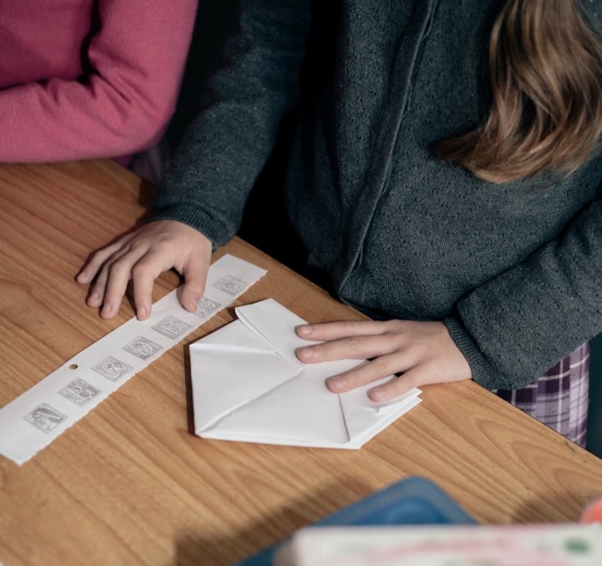 Students make origami printer's hats out of paper