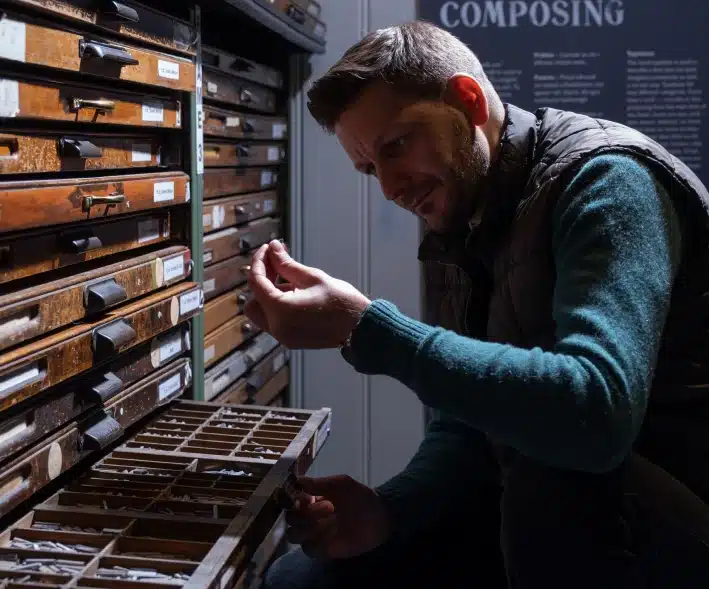 man looking at print artefacts