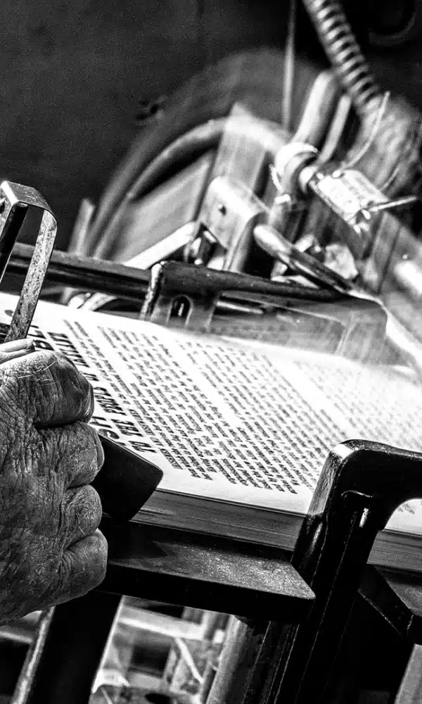 Black and White Image of Man working printing Press