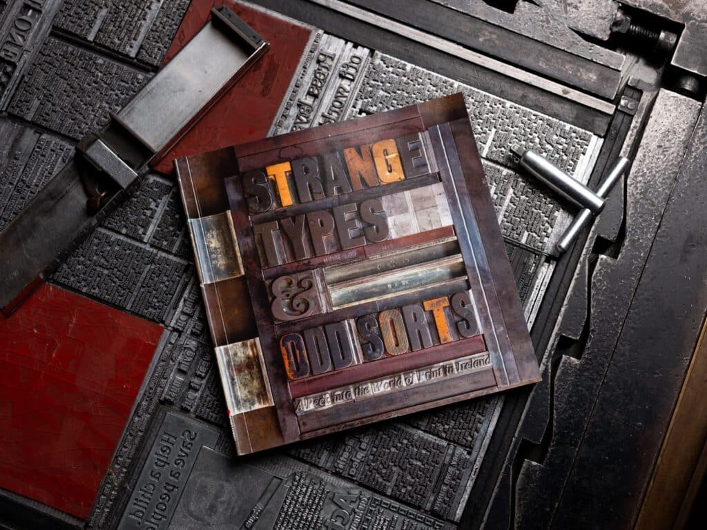 The book Strange Types and Odd Sorts rests on the last hot metal edition of the Sunday Press.