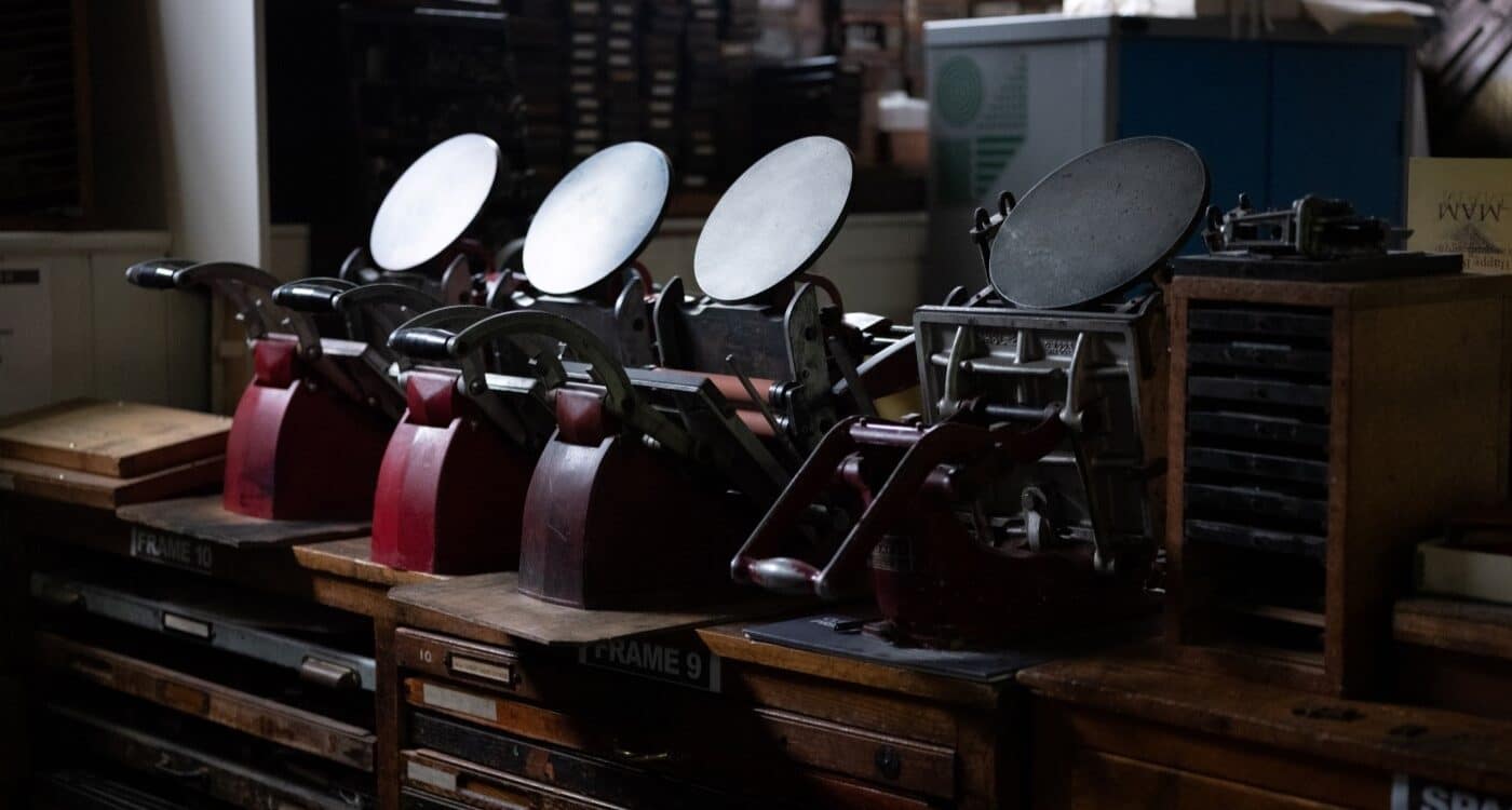 A row of tabletop Adana printing presses