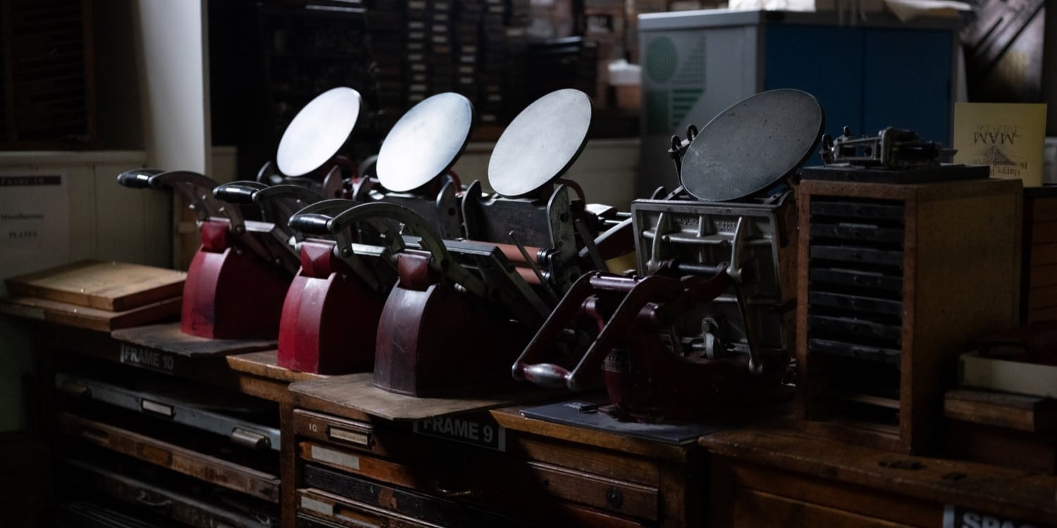 A row of tabletop Adana printing presses