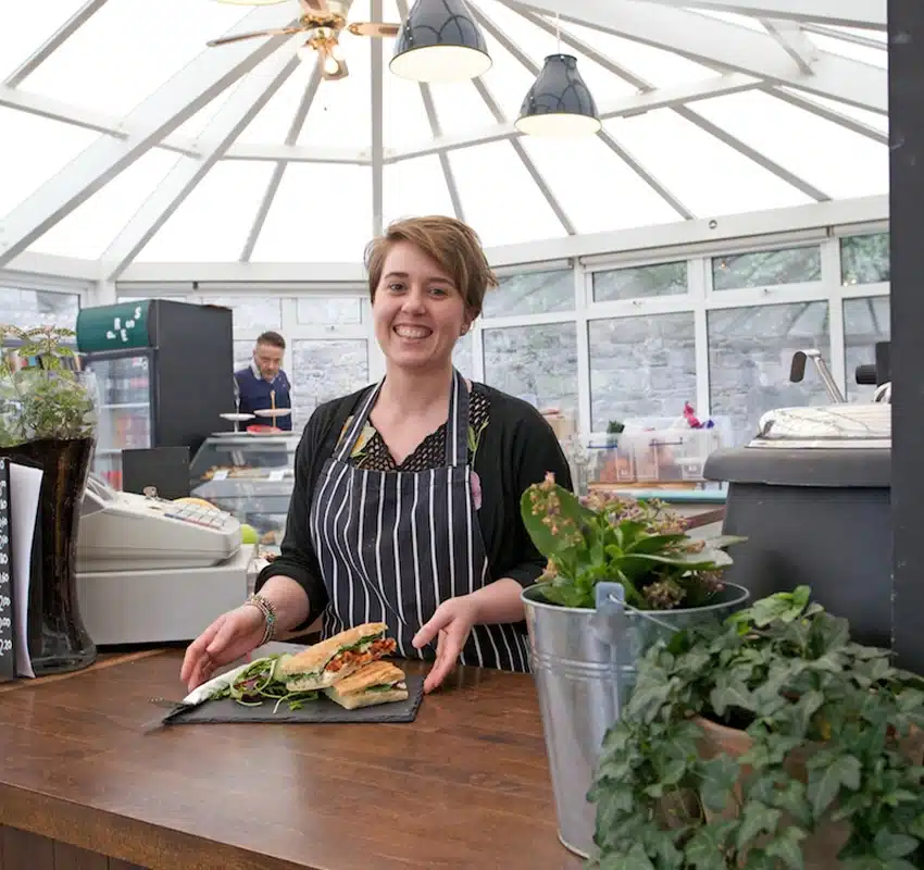 Server smiling with food at Press Cafe