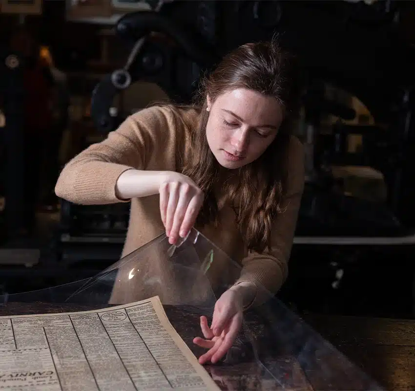 Woman examining print artifact