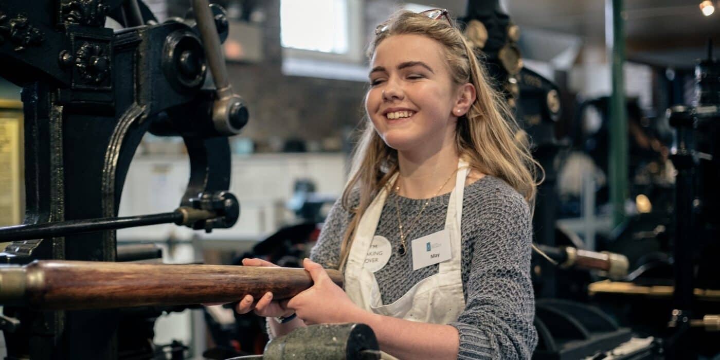 student operating columbian press