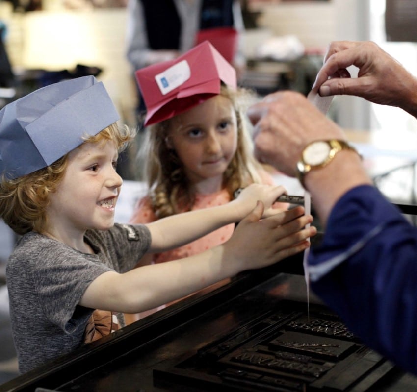 Children smile at seeing a poster they just printed