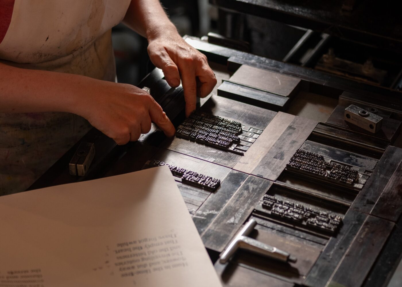 A compositor adjusting type inside a forme to prepare it for printing