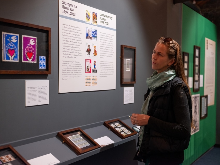 A visitor reads an information panel in the Miniature Masterpieces exhibition