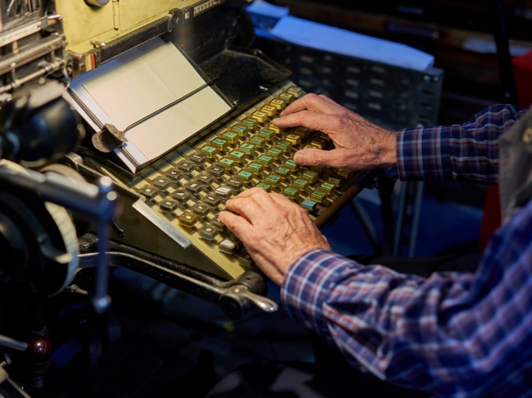 An operator types on a Linotype keyboard
