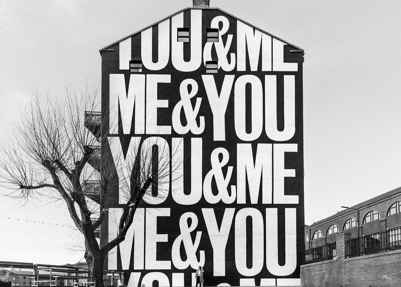 A mural of white text on a black background on the side of a building