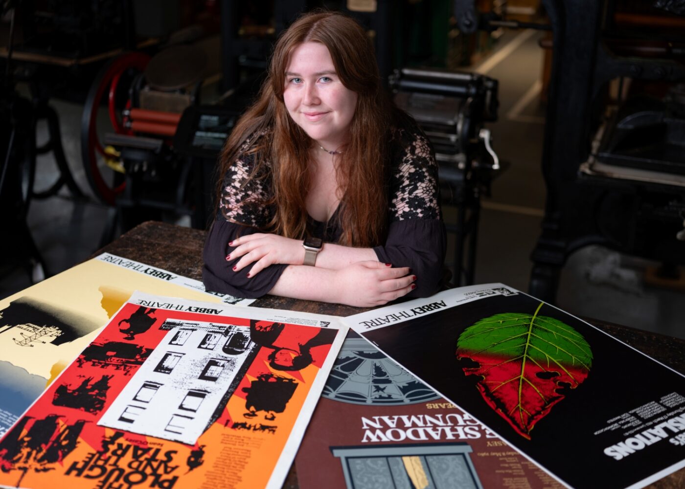Intern Niamh poses with four Abbey Theatre posters