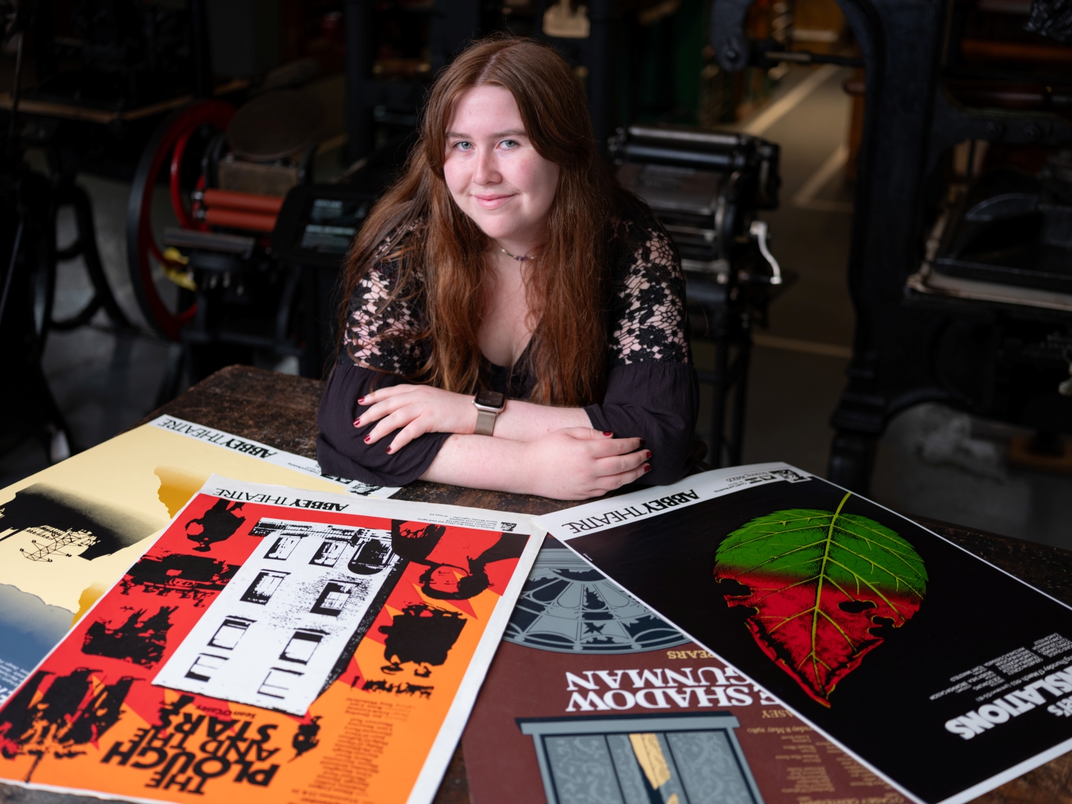 Intern Niamh poses with four Abbey Theatre posters