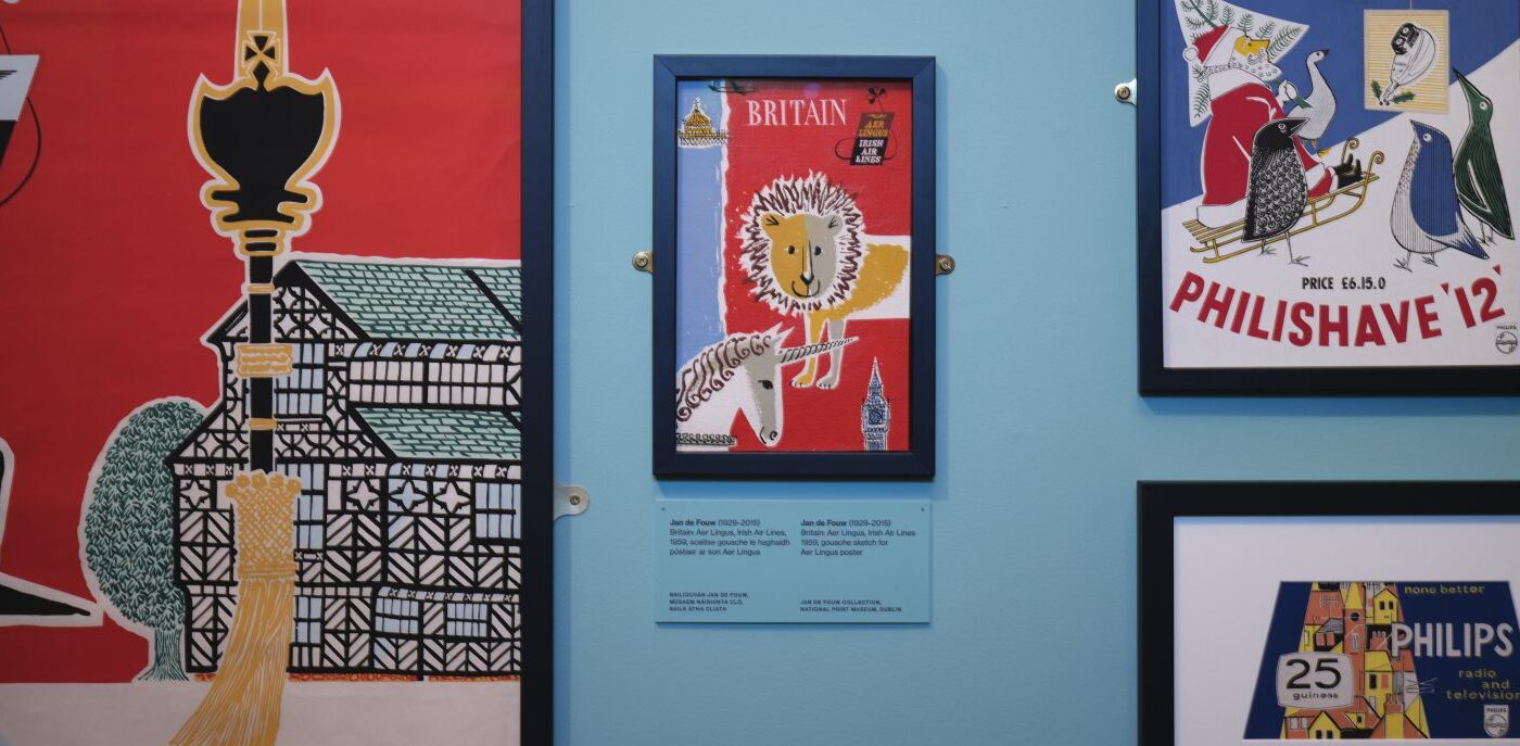 Various poster advertising travel and products hanging on a pale blue wall.