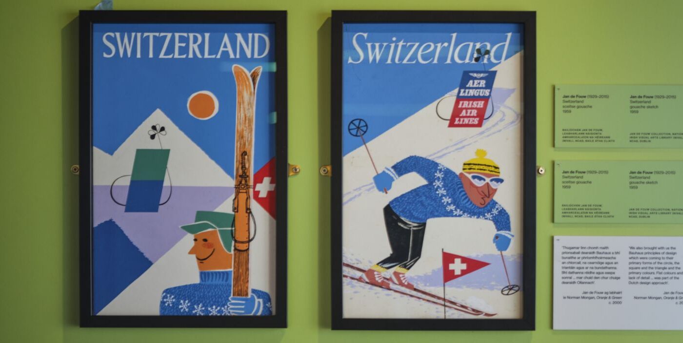 Two posters advertising travel to Switzerland hanging on a bright green wall