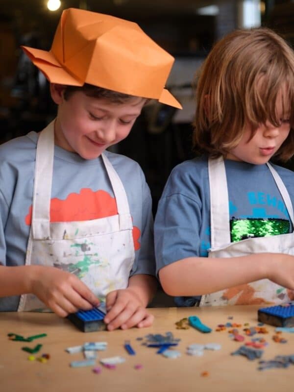 Two young boys look downwards as they play with LEGO.