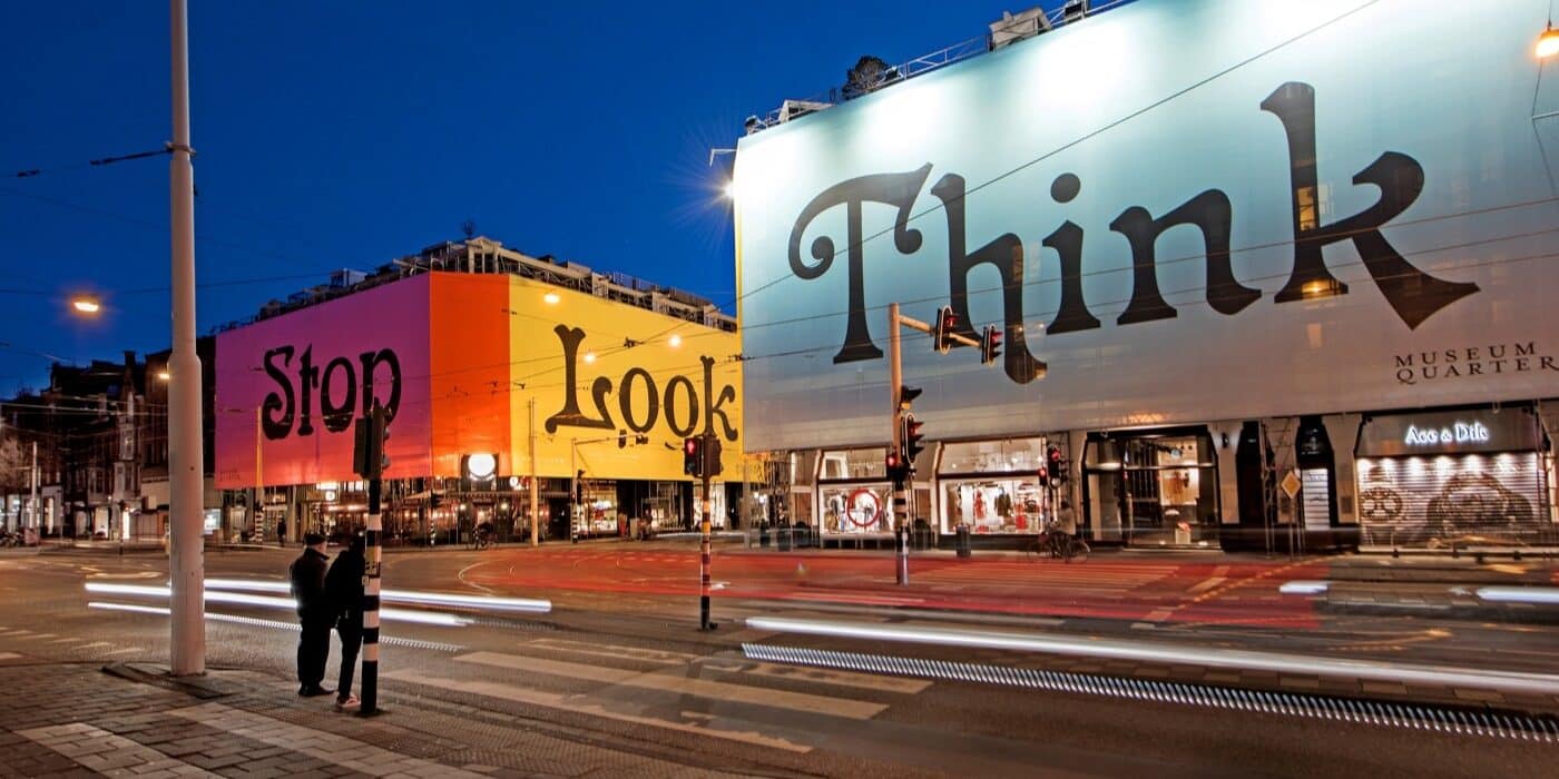 Large graphics on buildings at twilight.