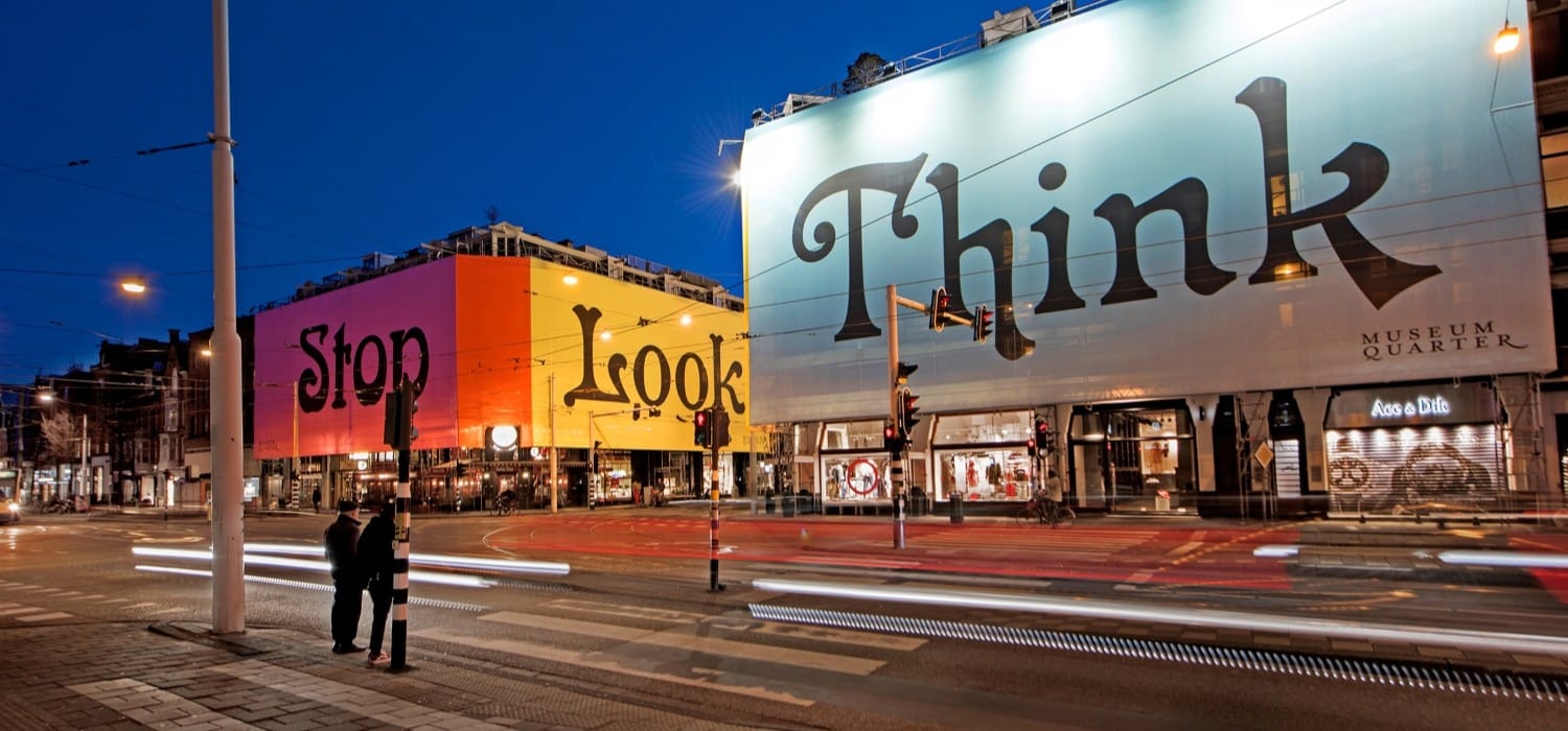 Large graphics on buildings at twilight.